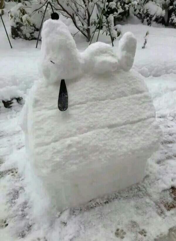 A snow sculpture resembling a cartoon character with a droopy eye.