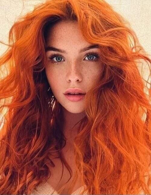 Portrait of a woman with vibrant orange hair.