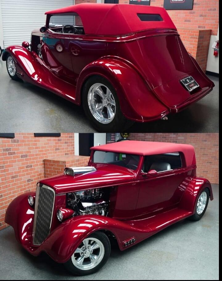 A stunning red custom hot rod car with a convertible top, showcasing its powerful engine and classic design.