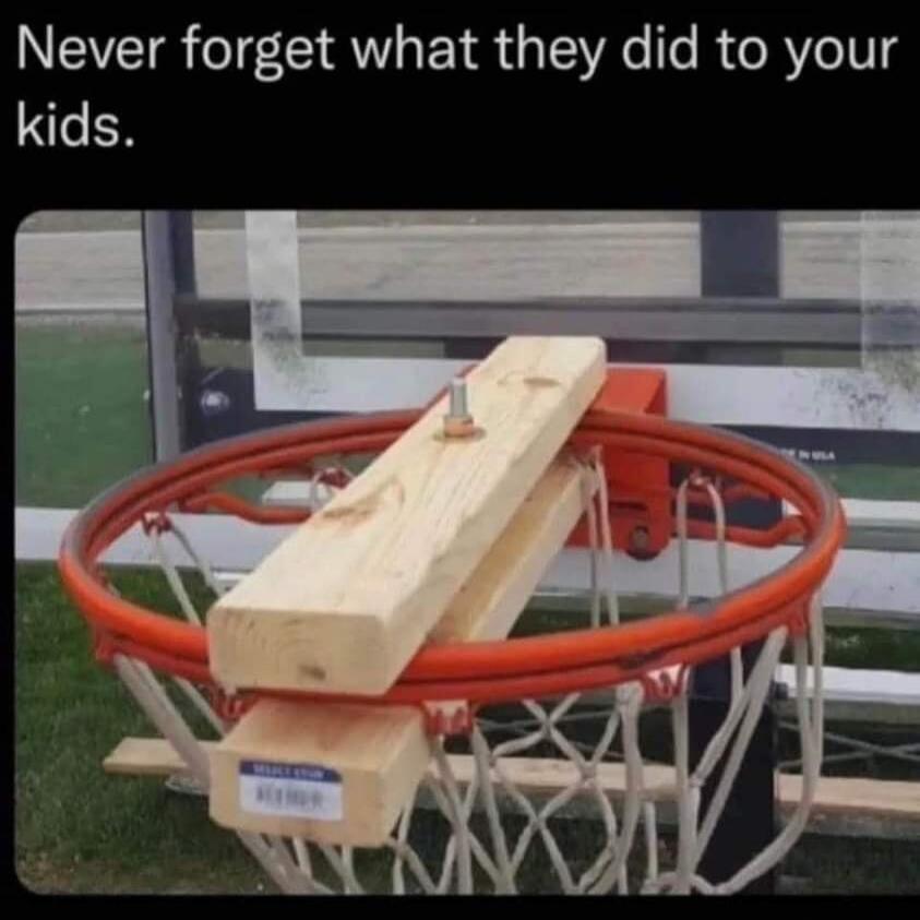 Never forget what they did to your kids. A basketball hoop is shown with two wooden planks bolted across the rim, making it impossible to play or score.