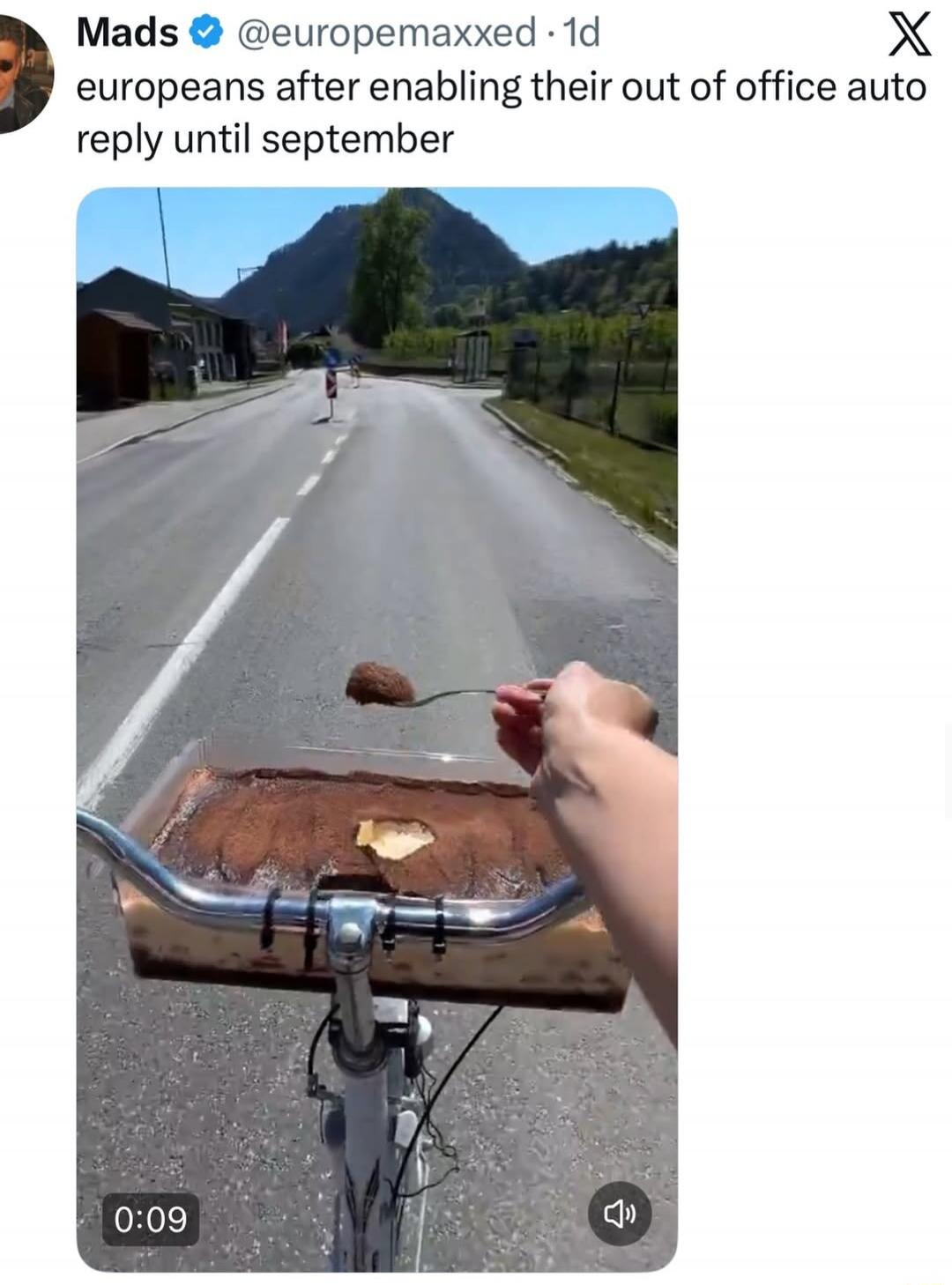 europeans after enabling their out of office auto reply until september. A person is riding a bicycle and eating tiramisu from a container attached to the handlebars.