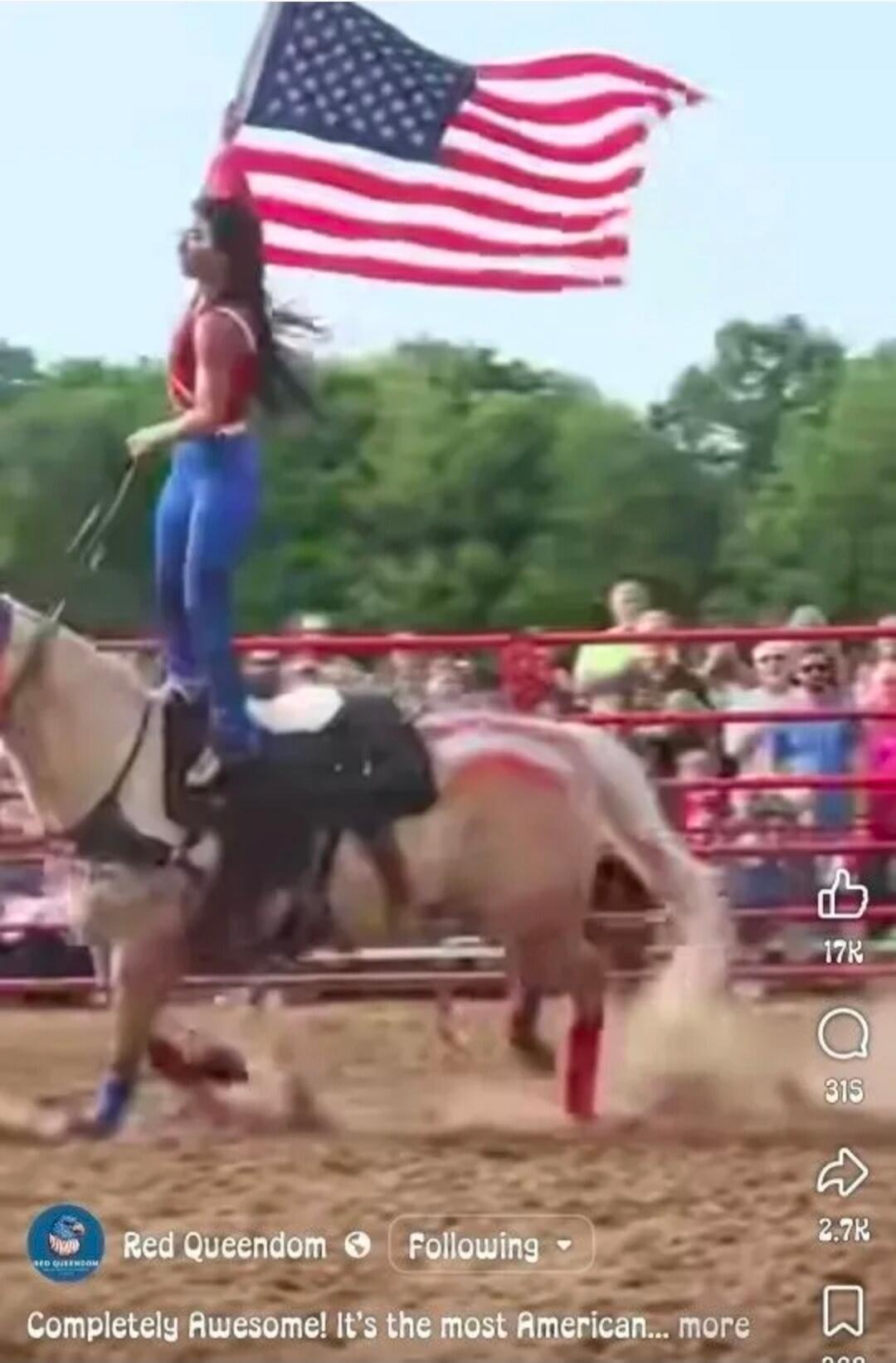 Red Queendom Following Completely Awesome! It's the most American... A woman in a red top and blue pants stands on a galloping horse, holding a large American flag. The horse has red markings, and a crowd watches from behind a fence.