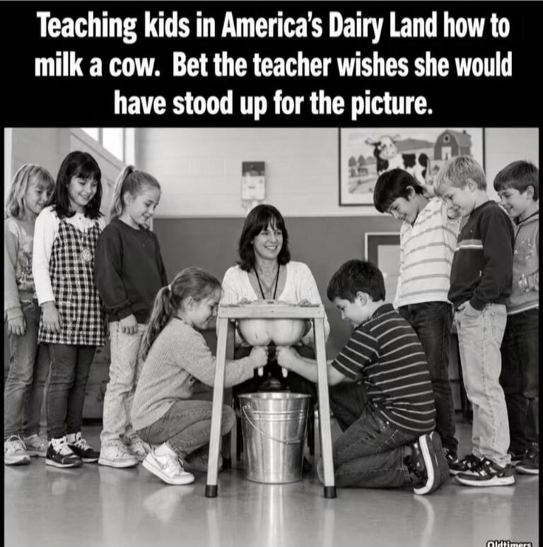 Teaching kids in America's Dairy Land how to milk a cow. Bet the teacher wishes she would have stood up for the picture.