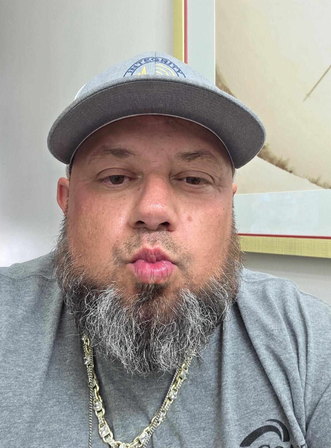 INTEGRITY. A man with a beard and a cap making a kissing face.