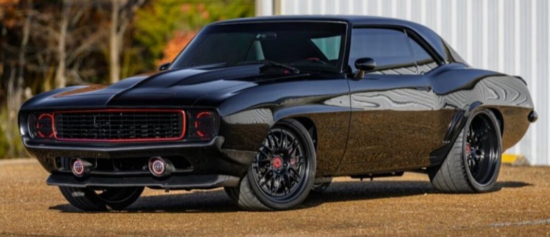 Black modern-classic muscle car with red accents and sporty customization.