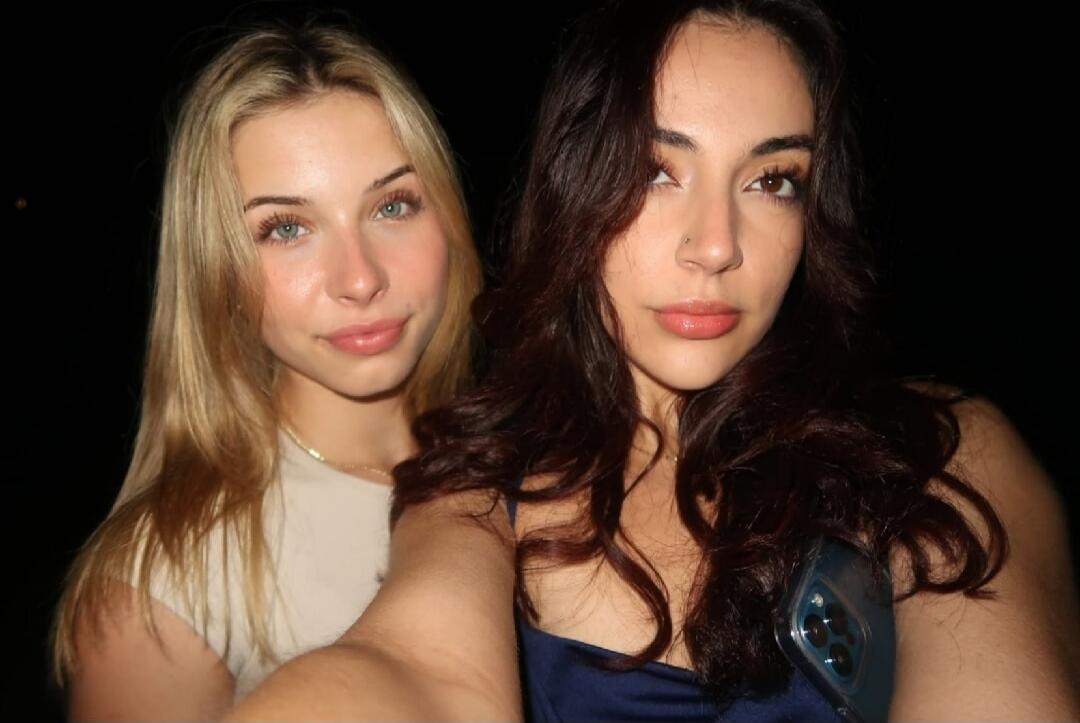 Two women posing for a selfie at night.