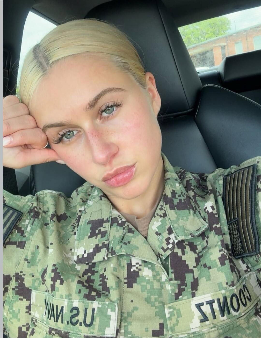 A woman in a U.S. Navy camouflage uniform, possibly named Coonts, is sitting in a car.