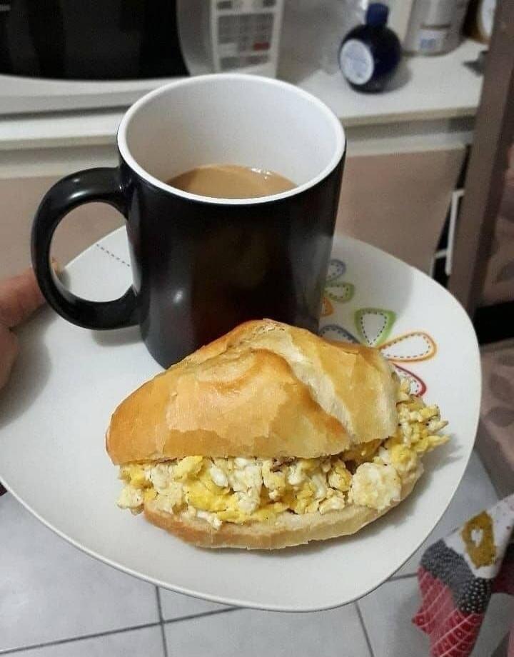Egg salad sandwich on a roll with a mug of coffee