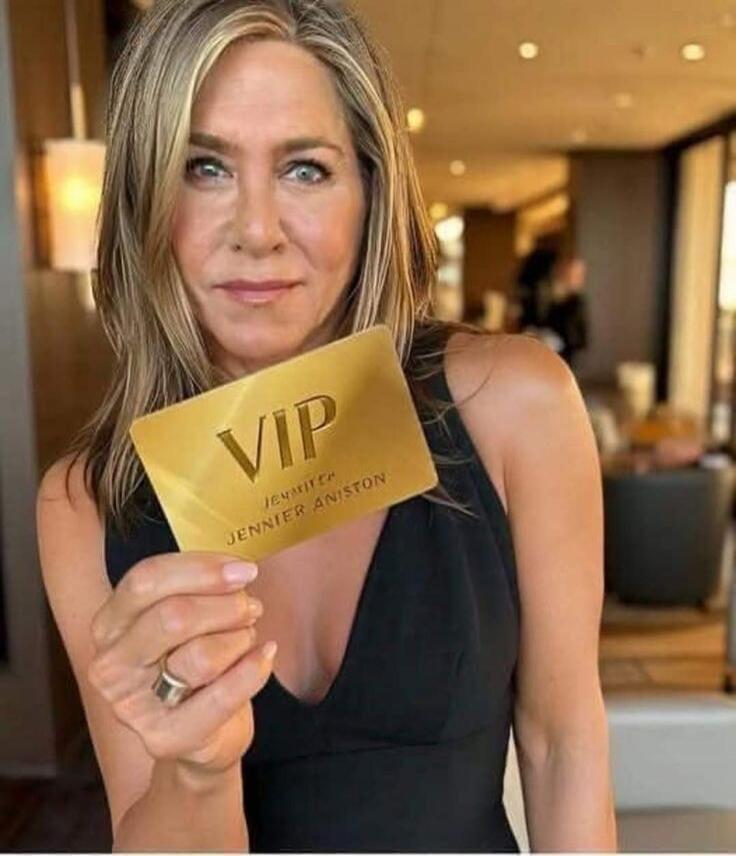 Jennifer Aniston holds a golden VIP card that says 'VIP Jennifer Aniston'.