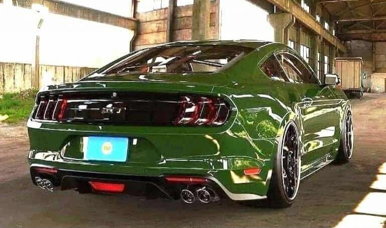 Green Ford Mustang (rear view) parked in an indoor or warehouse setting.