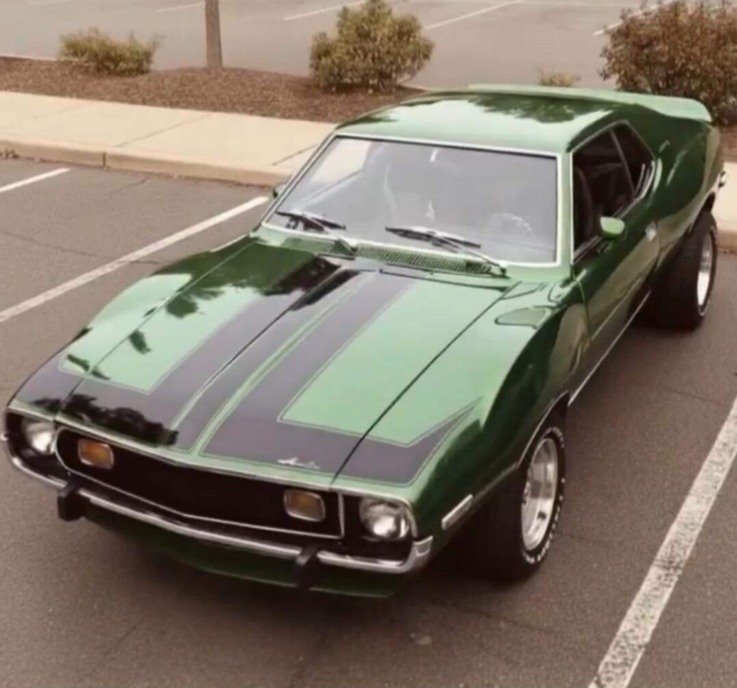Green classic muscle car with black racing stripes
