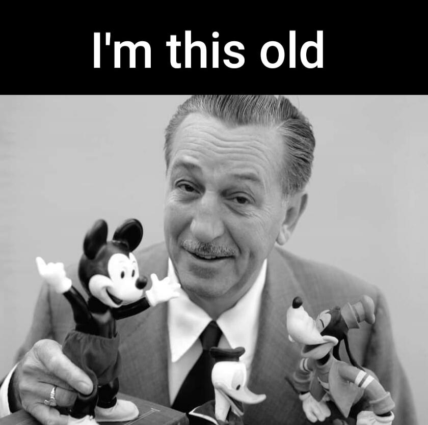 I'm this old. A black and white image of Walt Disney smiling, surrounded by figurines of Mickey Mouse, Donald Duck, and Goofy. The text 'I'm this old' is displayed above him.