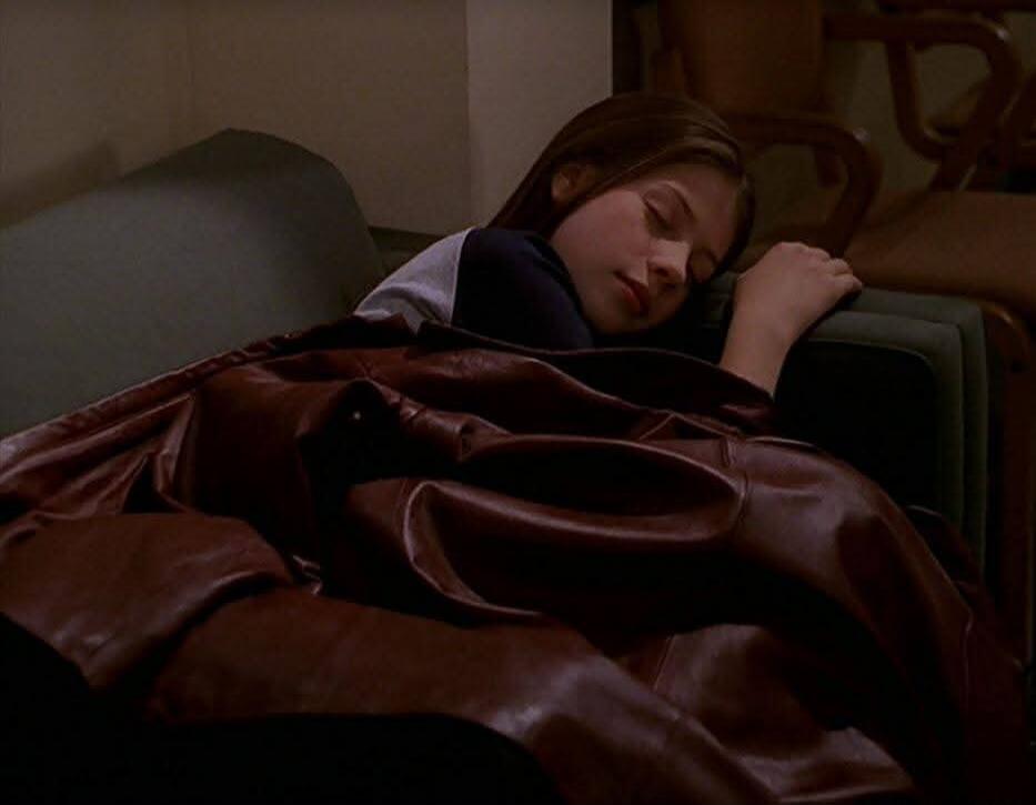 Session ID: 1059291.
A person sleeping on a couch, covered with a brown blanket.