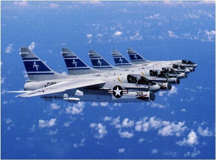 Six fighter jets in a tight formation above the clouds. The aircraft have blue tails with white markings and the US star insignia on the fuselage. The tail numbers and the number '30' are visible on the nearest plane.