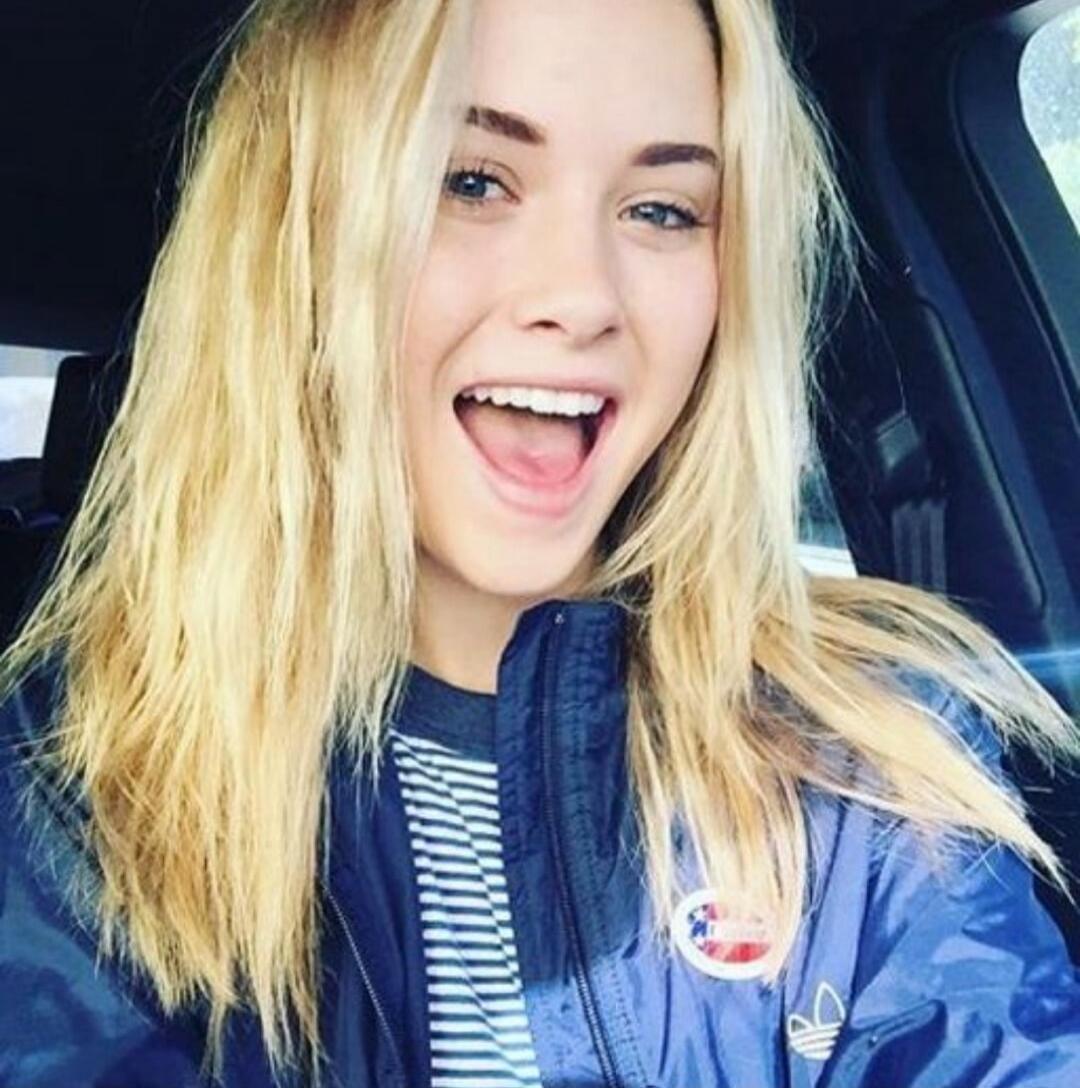 A young woman smiling in a car.