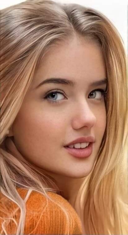 A close-up portrait of a young woman with blonde hair looking at the camera.