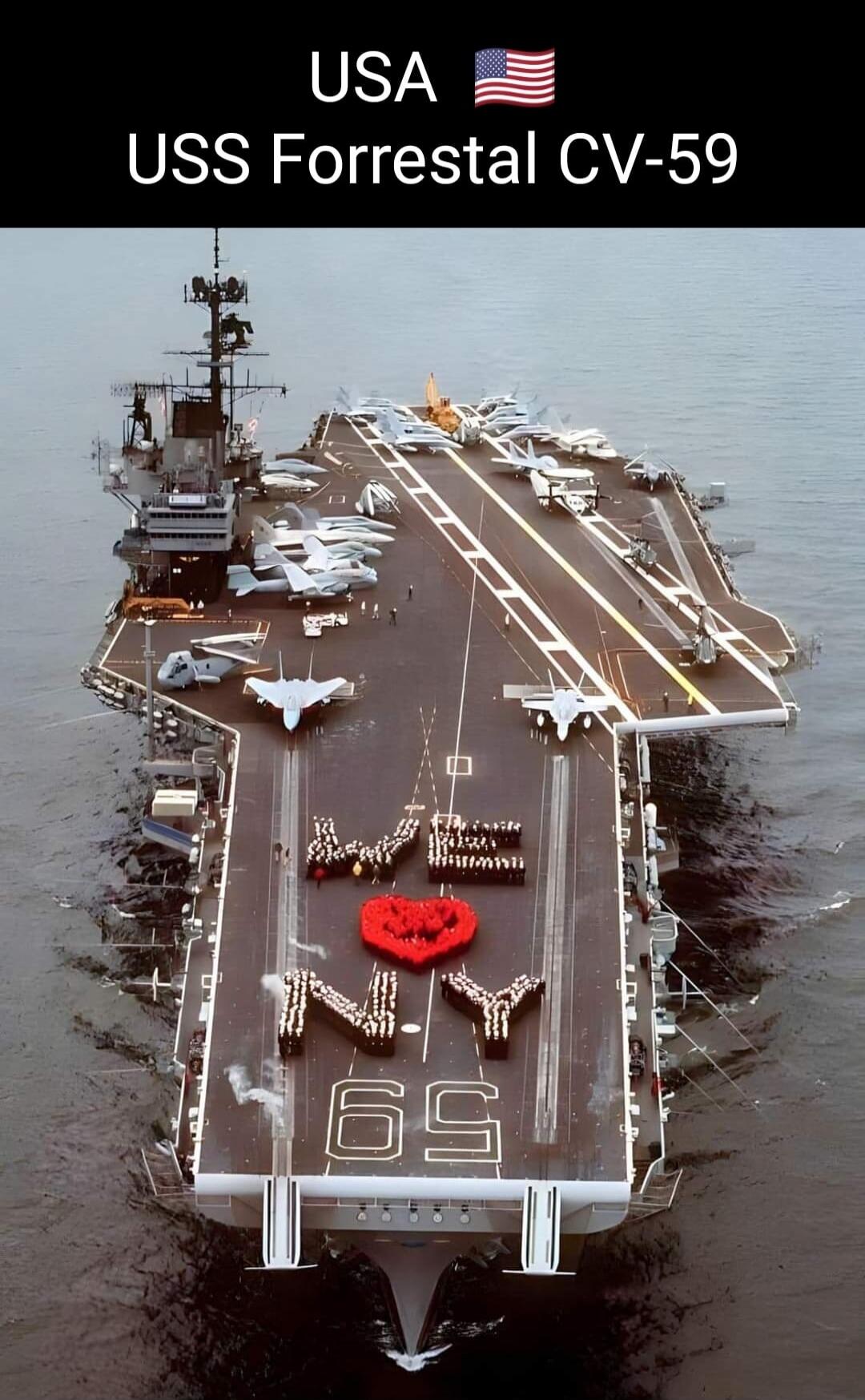 USA USS Forrestal CV-59. Sailors on the deck form 'WE ❤️ NY' with a red heart made of flowers, and the number '69'.