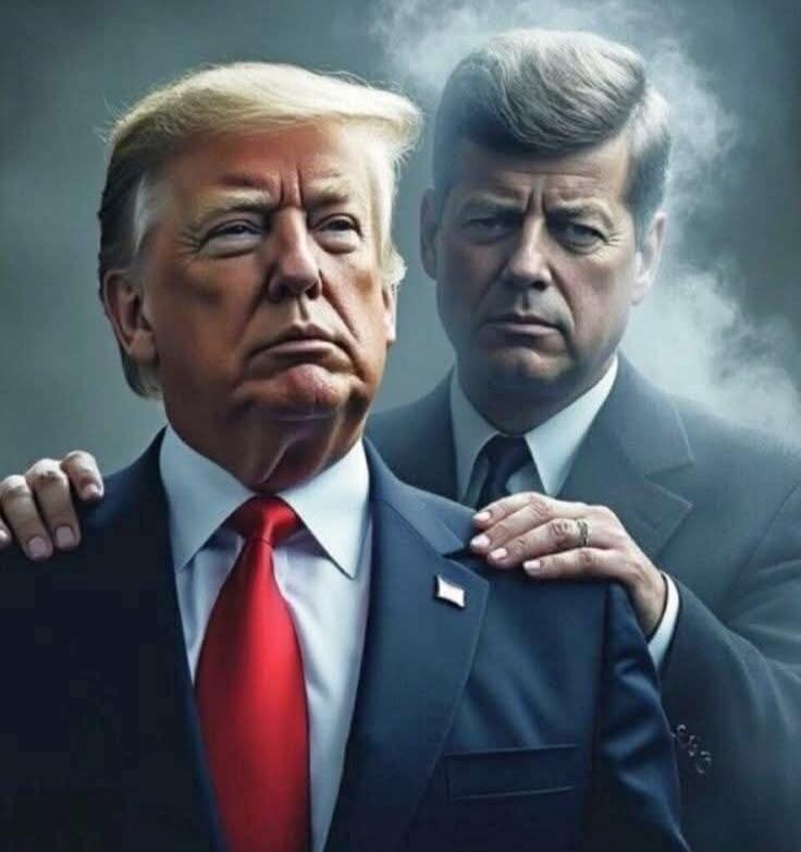 Two men in suits with one behind the other, one hand resting on the front man's shoulder, smoky background.