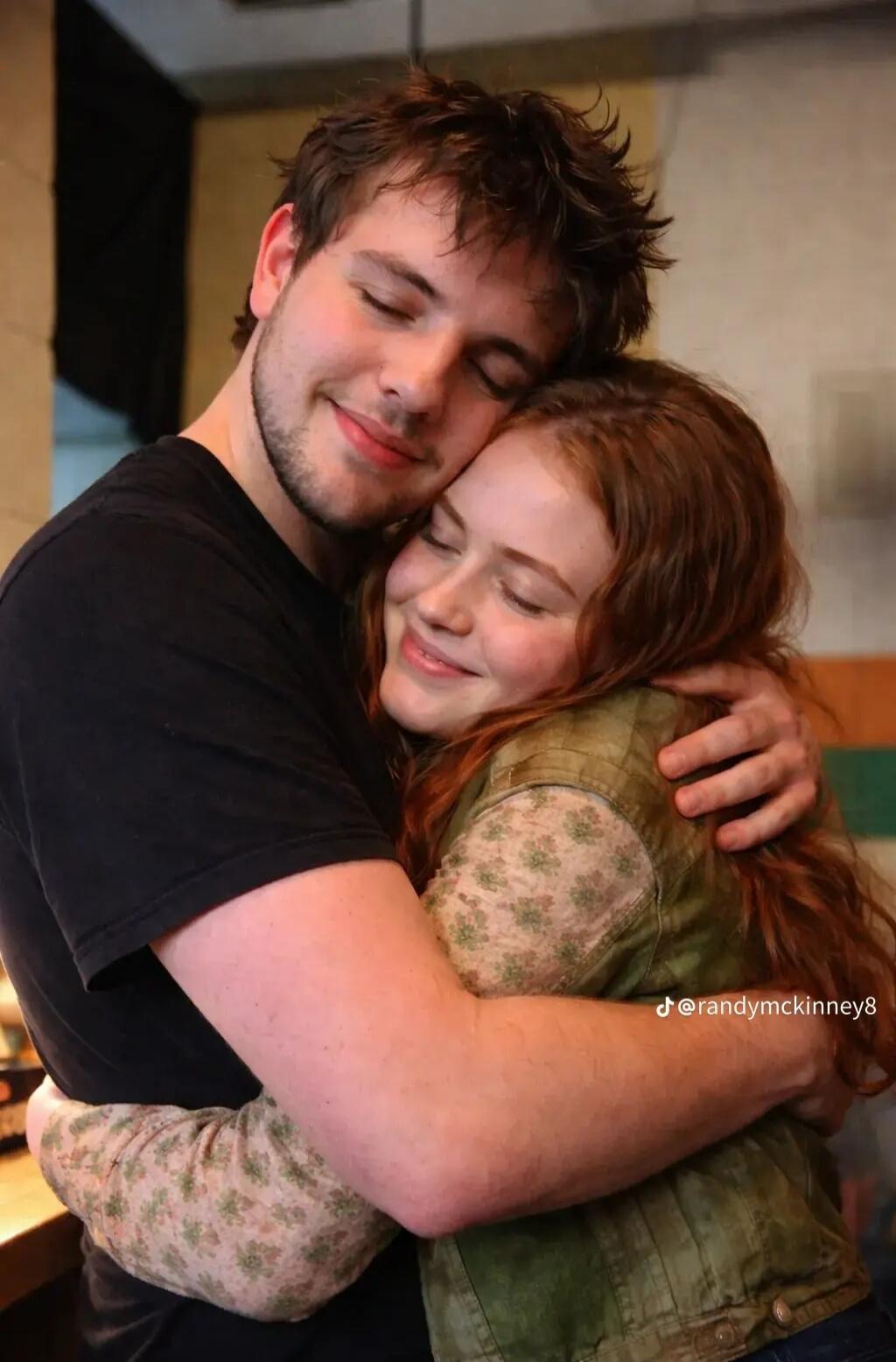 A man and a woman are embracing, both with their eyes closed and smiling, showing affection. The woman has red hair. Text on image: @randymckinney8