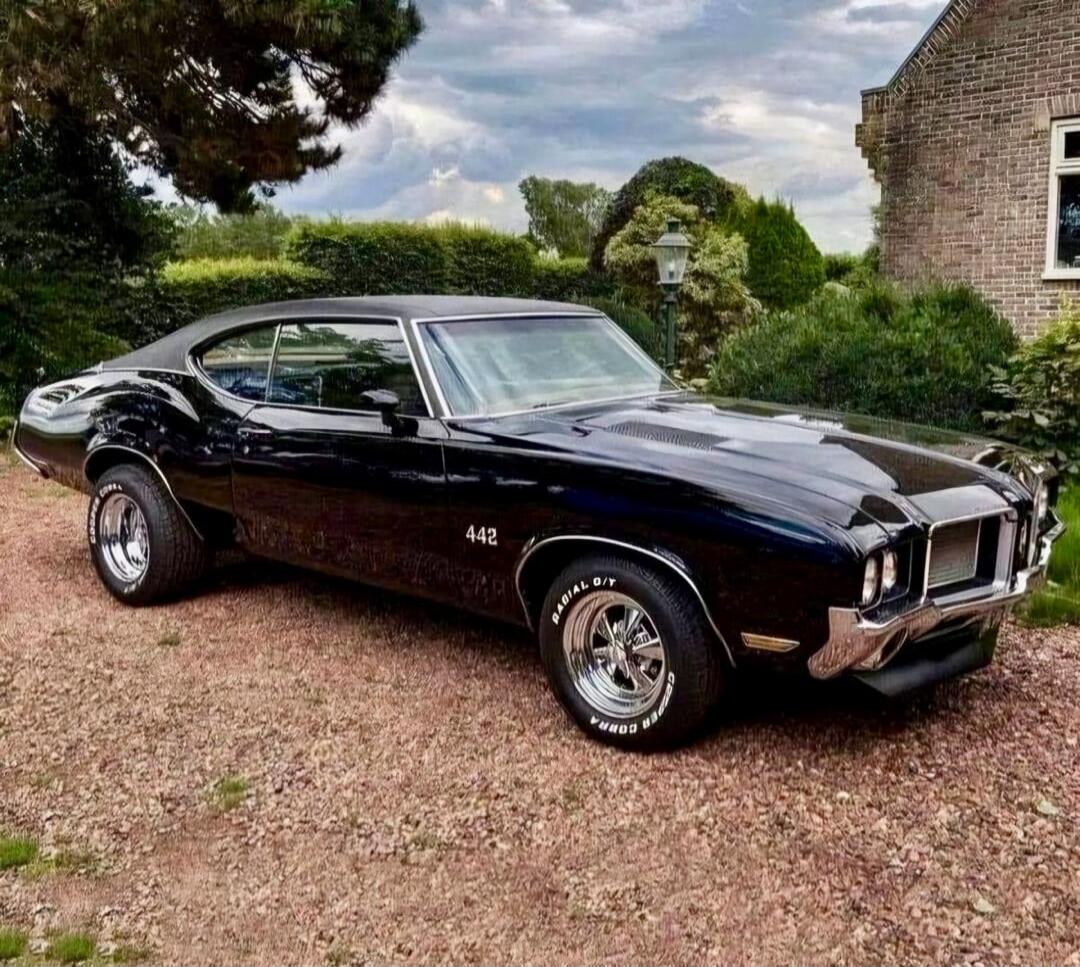 Oldsmobile 442 muscle car, black, classic car with white-letter tires. The side shows 442.