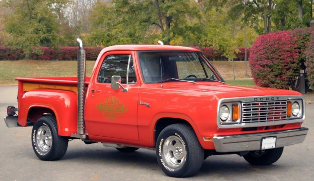 Red vintage pickup truck in a parking lot.