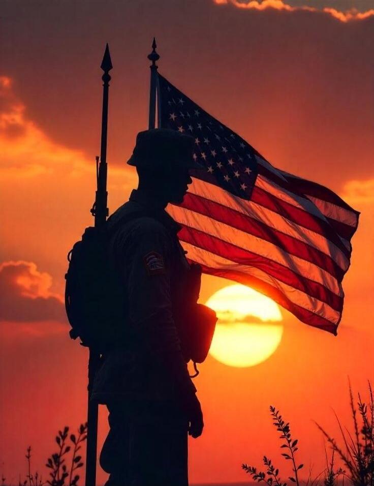 Silhouette of a soldier with an American flag at sunset.
