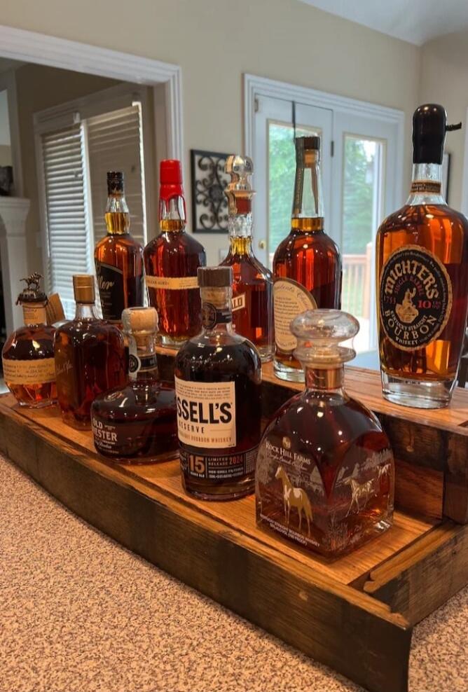 Assorted liquor bottles on a wooden bar counter.