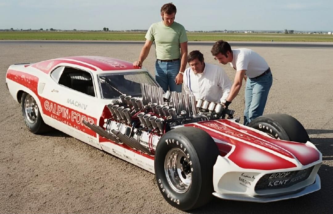Three men are gathered around a highly customized drag racing car, possibly a Ford Mustang, with multiple visible engine components and intake stacks. The car is white and red, with 'GALPIN FORD', 'MACH IV', 'SAN FERNANDO CALIF.', 'Engine by BREDIN', and 'BODY by KENT FULLER' visible on its body. The scene appears to be on an airfield or race track