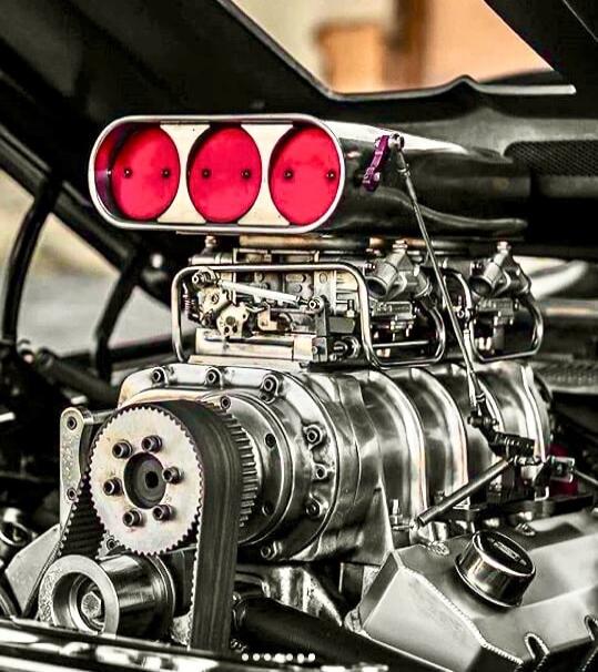 High-performance car engine with triple red intake trumpets. Session ID: 1071227.