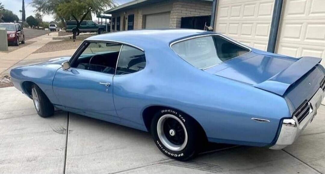 Blue classic car parked in driveway.