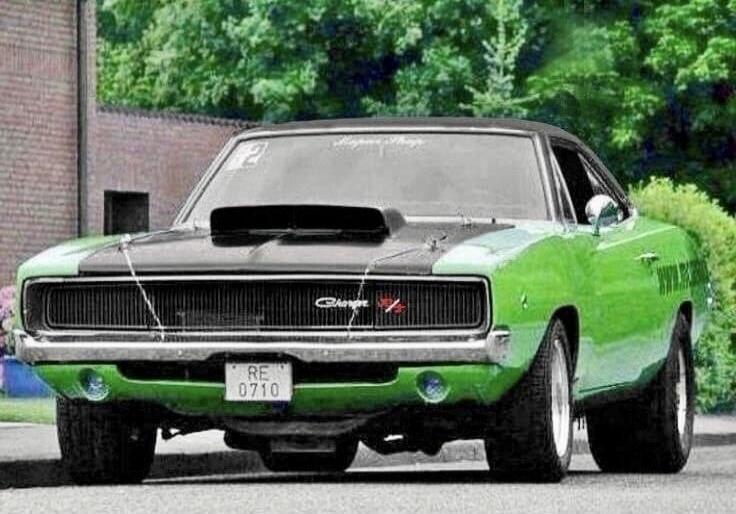 A classic green and black vintage car photographed outdoors.