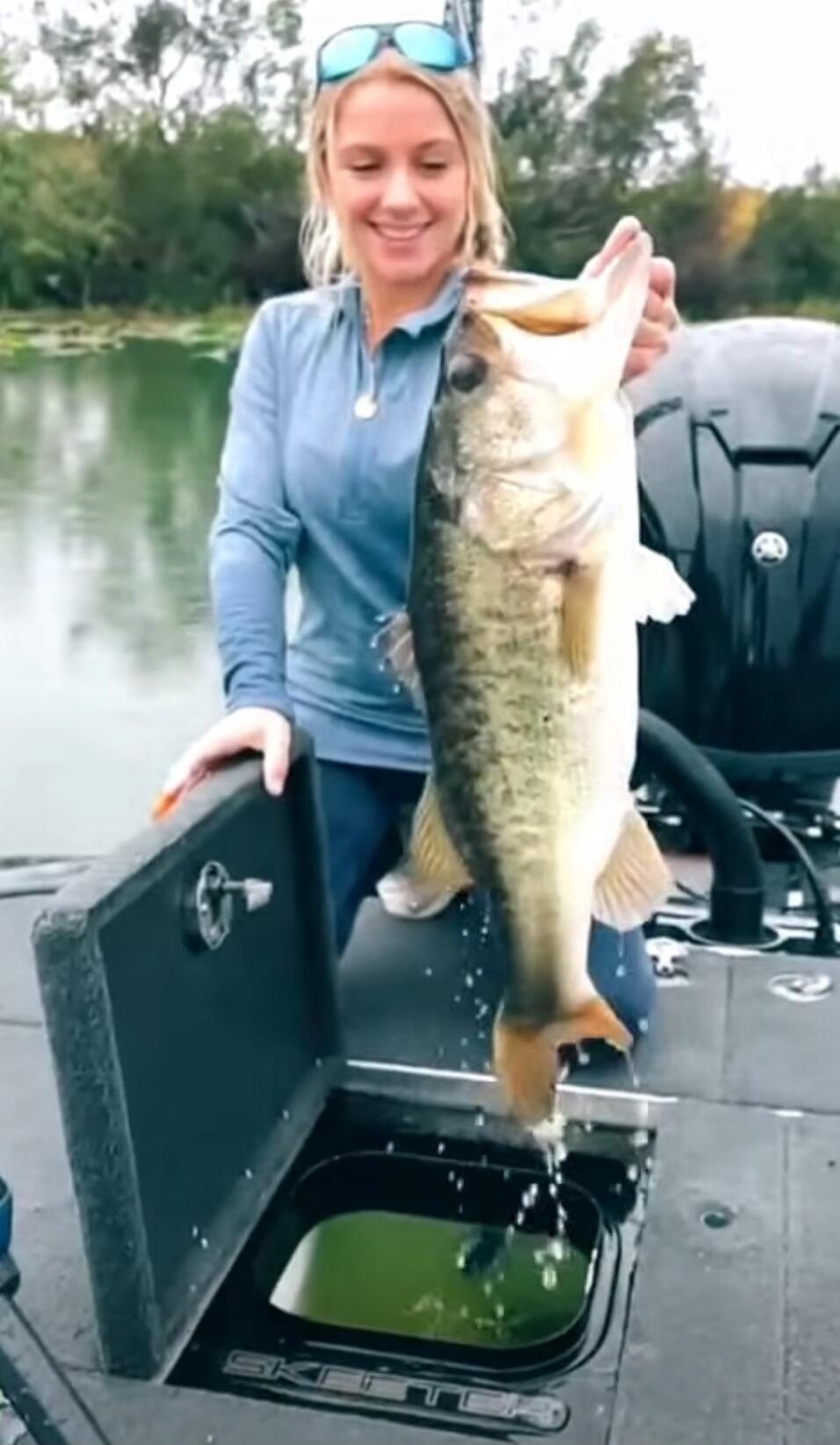 Woman on a boat holding a large fish.