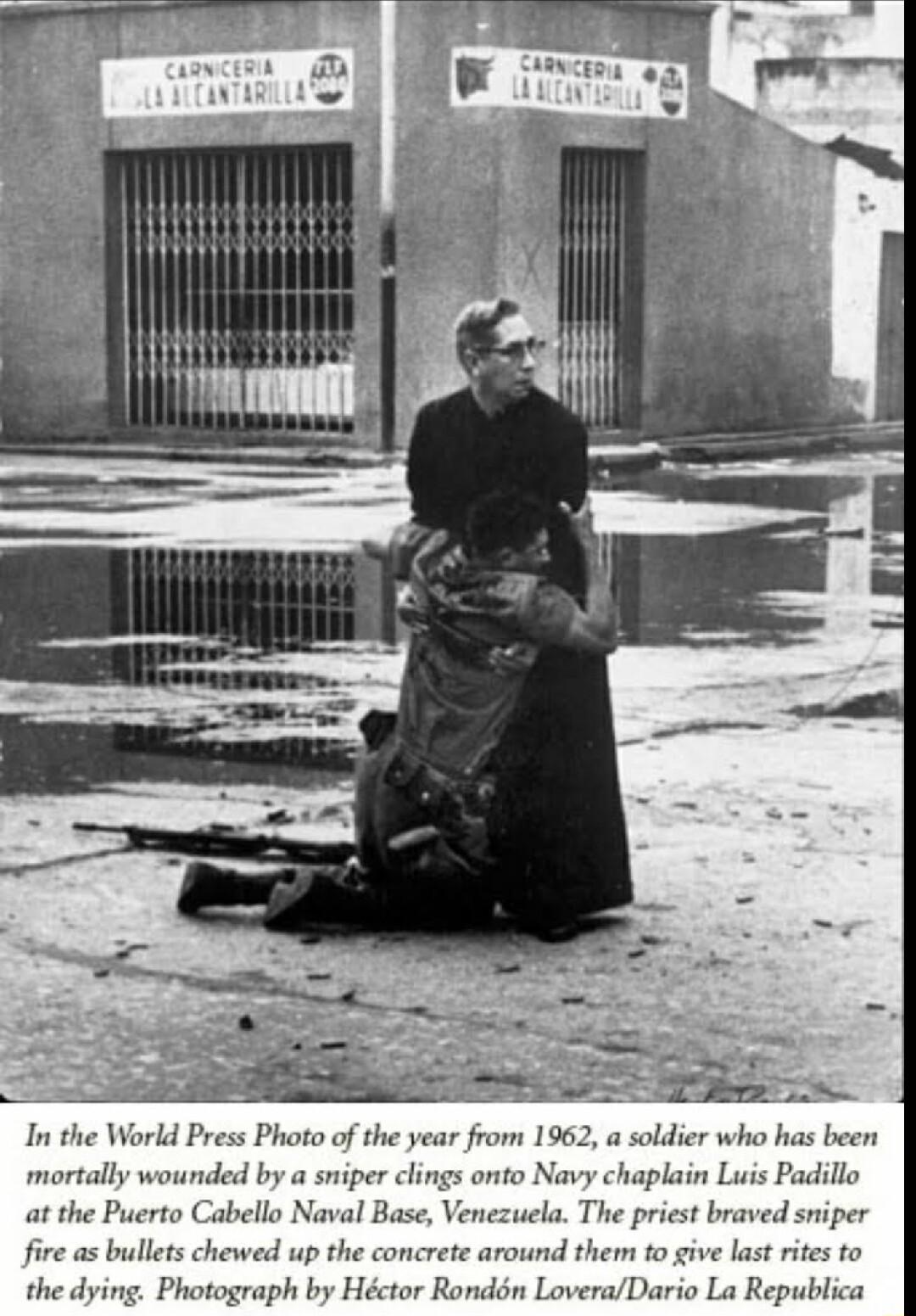In the World Press Photo of the year from 1962 a soldier who has been mortally wounded by a sniper clings onto Navy chaplain Luis Padillo at the Puerto Cabello Naval Base Venezucla The priest bra e as bullets chewed up the concrete around them to give last rites to the dying Photograph by Hctor Rondn LoveraDario La Republica