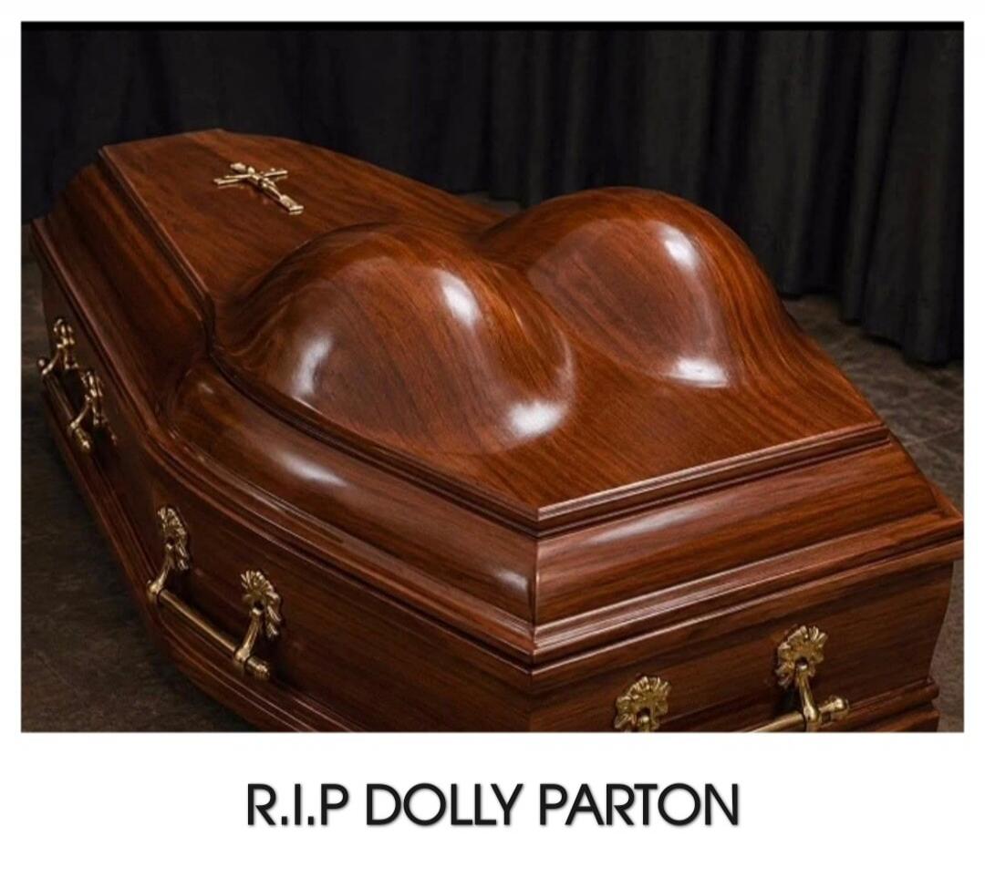 A wooden coffin with a lid shaped like a woman's breasts. Below the image, the text reads: R.I.P DOLLY PARTON.