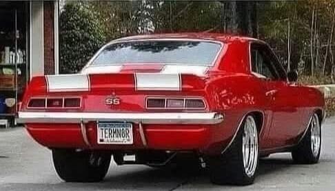 Red classic Chevrolet Camaro SS with white racing stripes. The license plate reads TERMINOR.