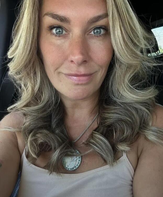 A close-up selfie of a woman in a car.