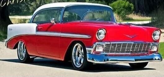 Classic red vintage car (1950s) with chrome details and whitewall tires.