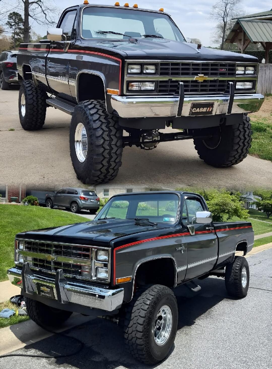 Two lifted classic Chevrolet trucks: a tall, chrome-front pickup with oversized off-road tires on top, and a darker gray/blue pickup with a red pinstripe on the bottom, both with lifted suspension and large wheels.