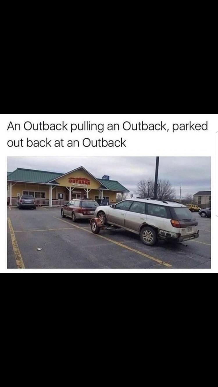 An Outback pulling an Outback parked out back at an Outback