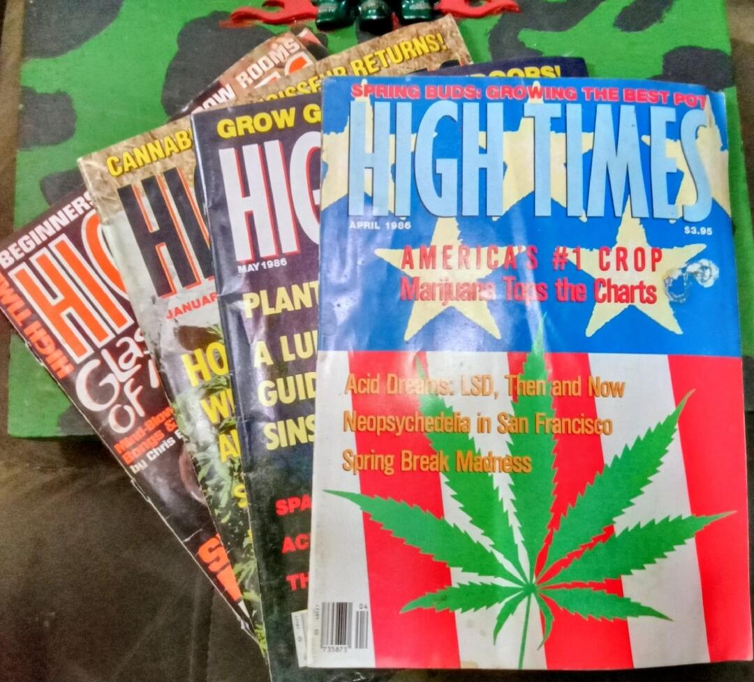HIGH TIMES (stack of magazines) – Cannabis-themed magazine covers. Visible titles include HIGH TIMES on multiple issues with large cannabis leaf imagery. Blue issue prominently reads HIGH TIMES with a large cannabis leaf and the headline phrases such as AMERICA'S ____ Marijuana Taxes the Charts. Other visible covers show words like GROW, BEGINNER, 