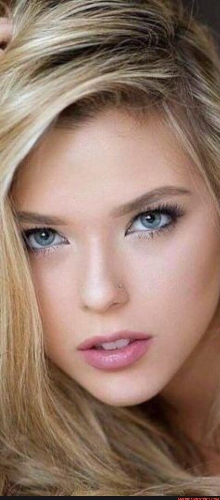 Close-up portrait of a blonde woman with blue eyes.