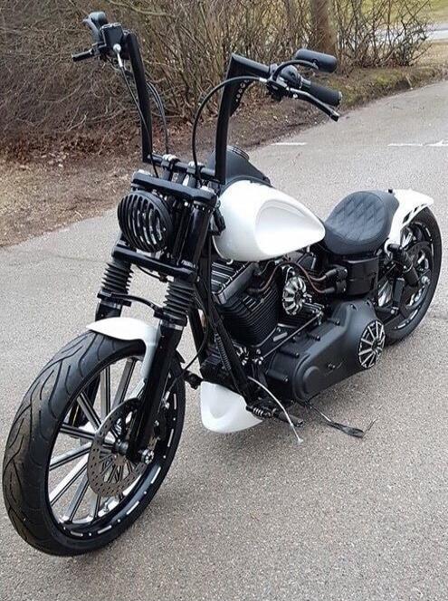 Custom black-and-white cruiser motorcycle with tall ape-hanger handlebars.