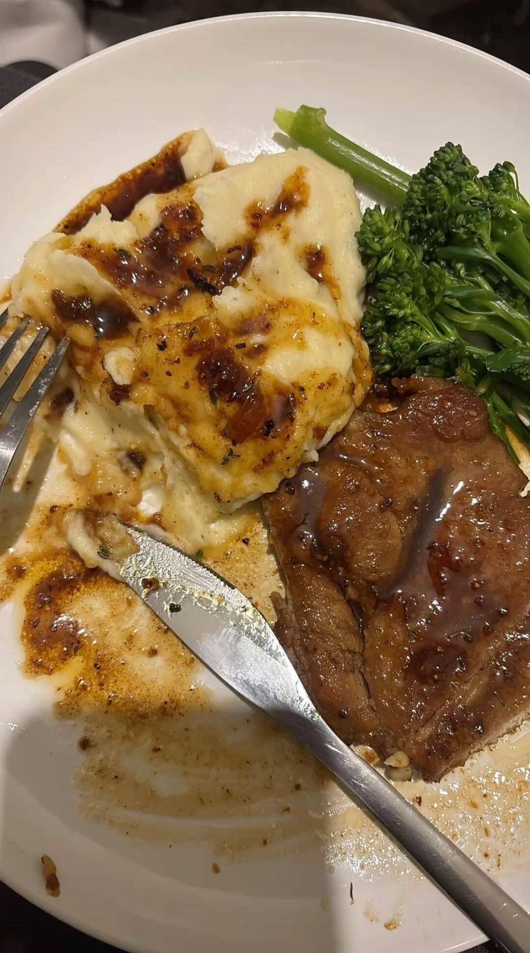 Mashed potatoes with gravy, steak, and broccoli.
