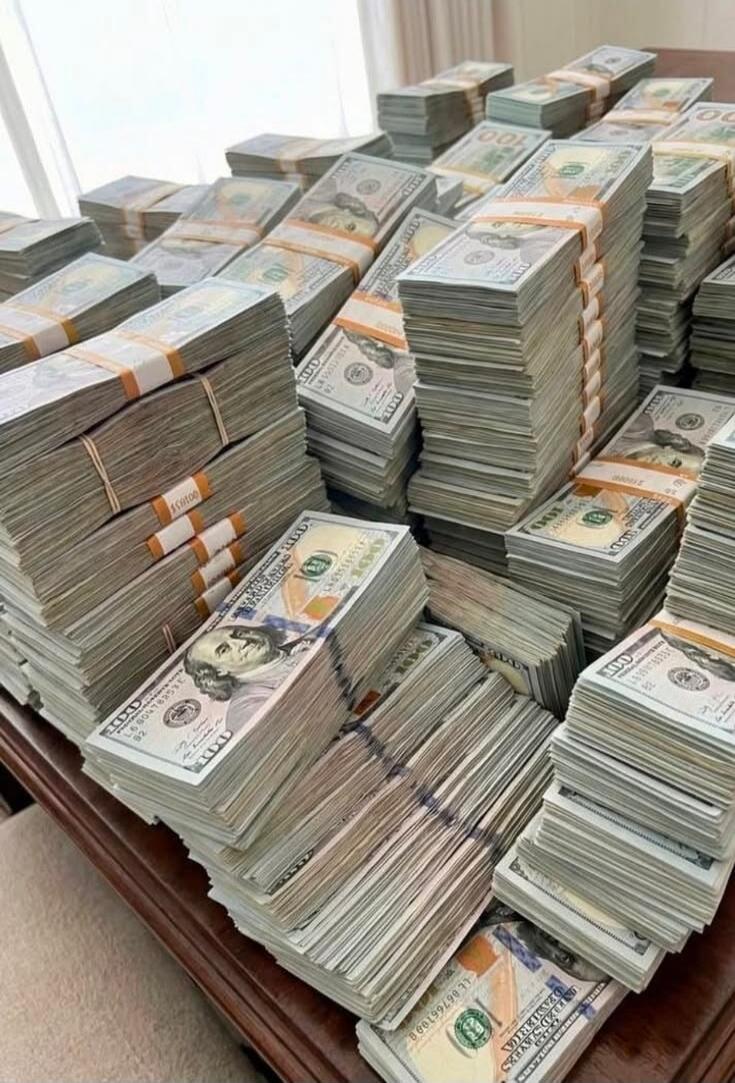 Bundles of US hundred-dollar bills stacked on a table.