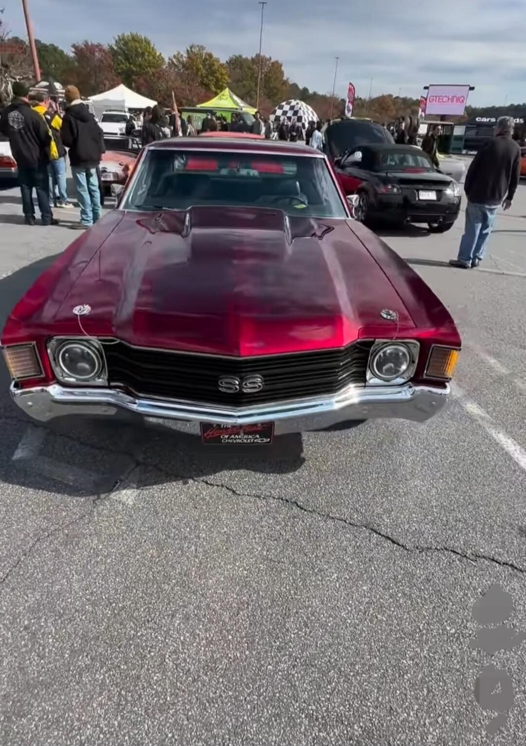 Chevrolet Chevelle SS at a car show (front view) shows a burgundy/classic muscle car with distinctive SS emblem on the grille.