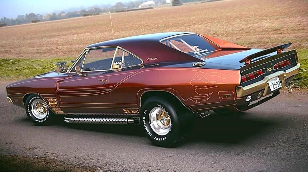 Red vintage muscle car photographed on a road (rear three-quarter view).