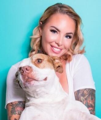 A smiling woman with a dog.