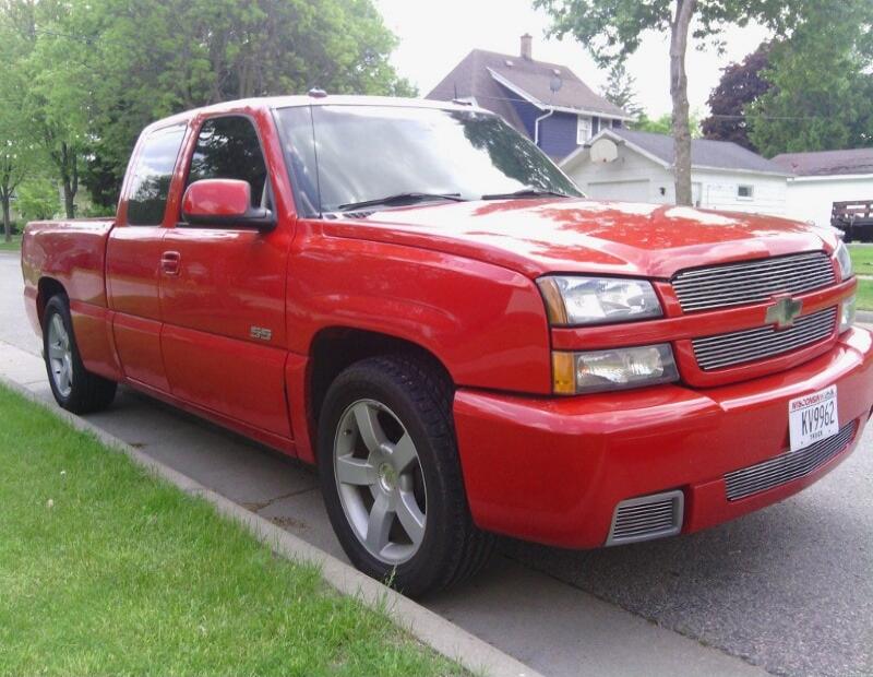 Red Chevrolet Silverado SS pickup truck parked on a residential street. Wisconsin license plate KV9962.